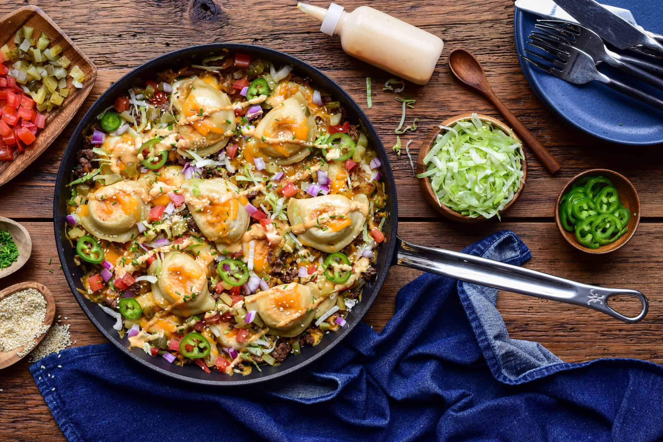 A cheeseburger skillet with pierogi, served with extra toppings on the side.