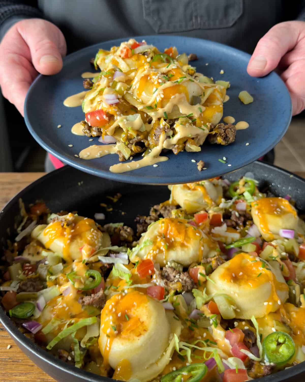A serving of a cheeseburger skillet with pierogies and burger sauce toppings.