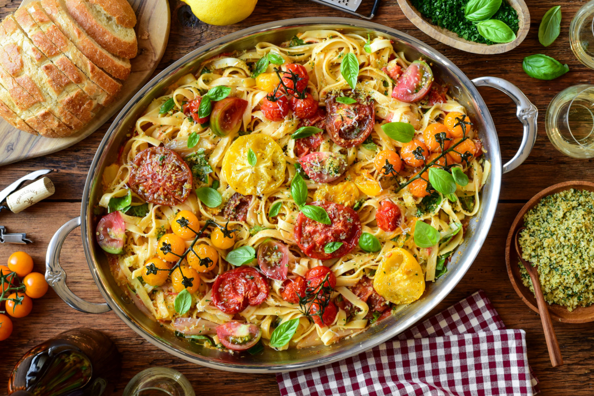 A large oval au gratin filled with a roasted heirloom tomato pasta with lemon-garlic panko and basil. Served with slices of bread, extra panko, lemon zest and extra herbs.