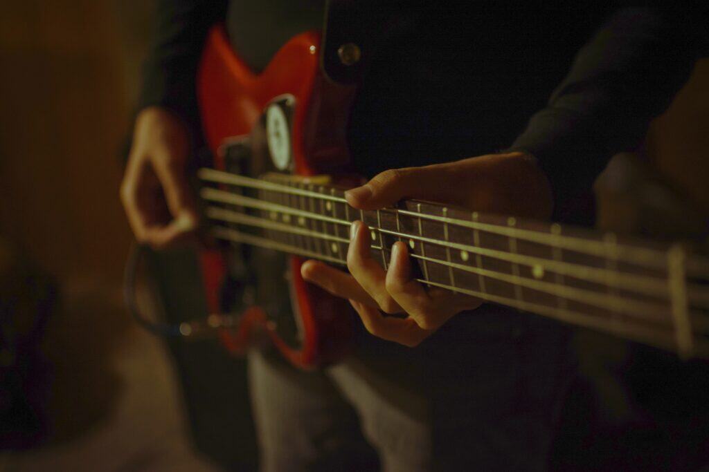 Beginner bass player on a red bass guitar