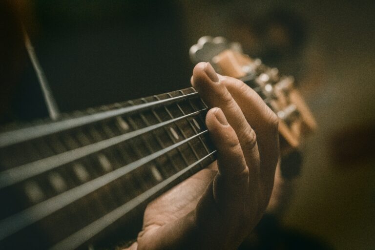 Close-up of hand pressing guitar strings near fretboard for soulful music.