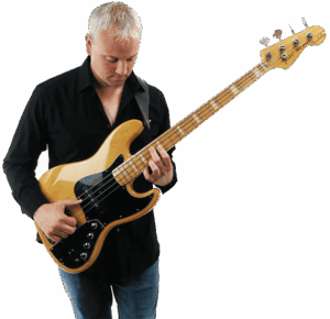 Mark Smith runs the online bass course TalkingBass. Here he stands holding a bass guitar.