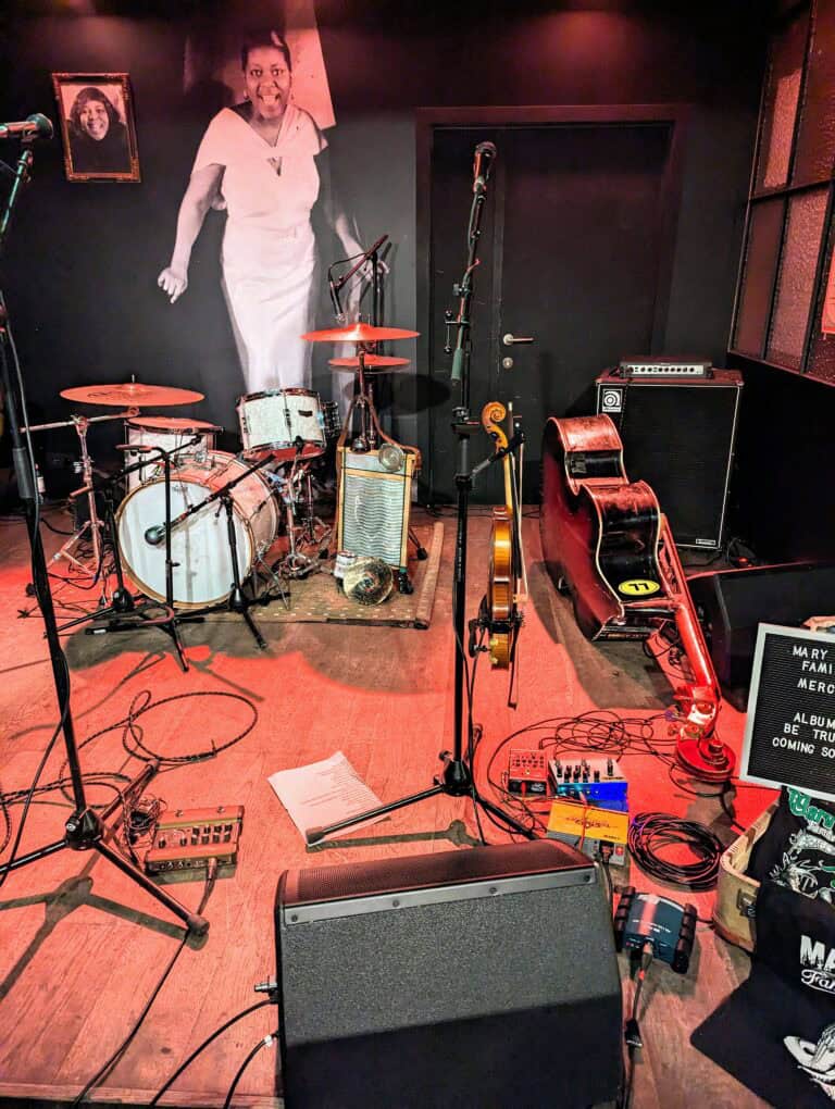 Joining a band means sharing a crowded stage with other who share your love of music. Here is a crowded stage with drums, bass, fiddle, speakers, cables.