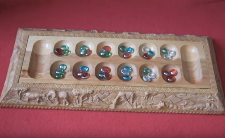 African marble game for children on a wooden board.