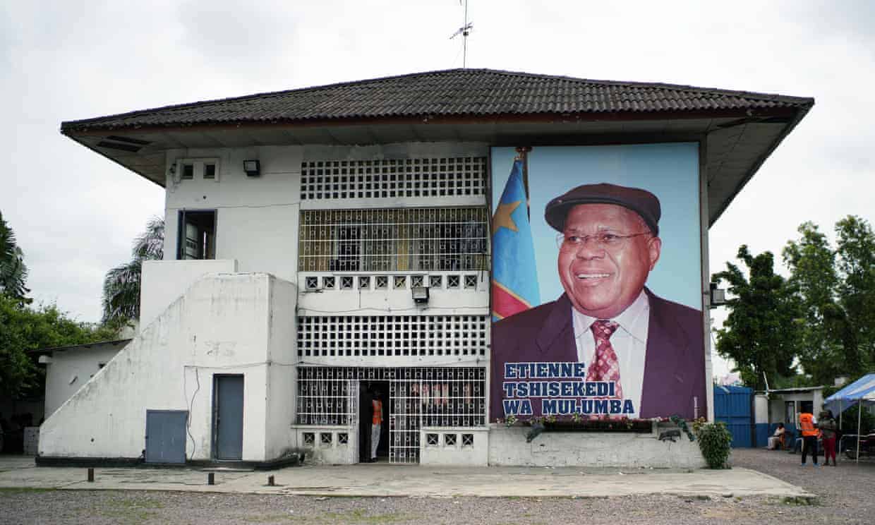 Community building with a large portrait of a man on the wall, featuring the Tanzanian flag.