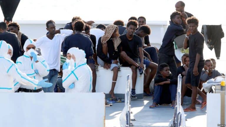Group of refugees waiting on a boat in Africa, seeking safety and better opportunities.