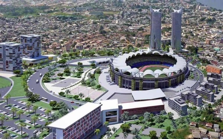 Aerial view of Gabon's new modern stadium surrounded by urban development and greenery.