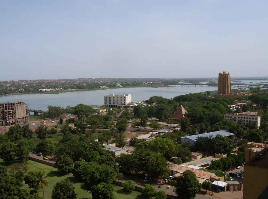 Panoramic view of Mali city featuring a river, tall buildings, and abundant green spaces.