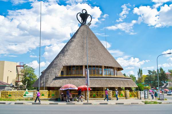 Traditional Basotho hut in Lesotho with thatched roof and circular design.