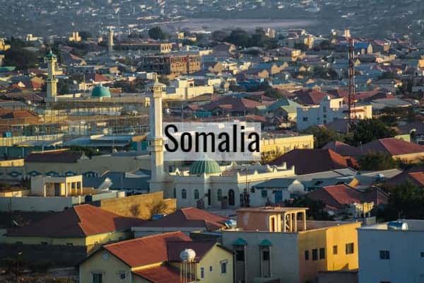 A panoramic view of Mogadishu, Somalia, showing colorful rooftops and city buildings at sunset.