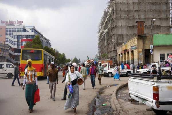 Busy street scene in Ethiopia with pedestrians, vehicles, and construction.