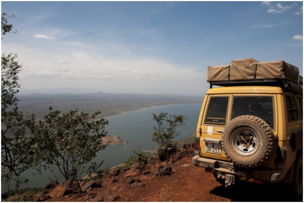 Off-road vehicle overlooking a scenic lake in Kenya, perfect for adventure travel.