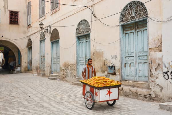 Vibrant street scene in an African city with a street vendor selling snacks.
