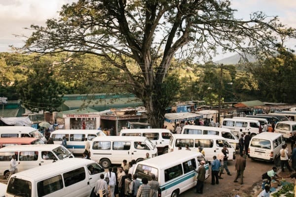 Bustling transportation hub with numerous vans and people in Malawi.