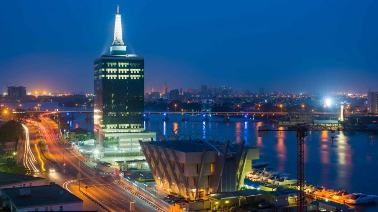 Lagos skyline at night featuring iconic buildings and vibrant city lights.