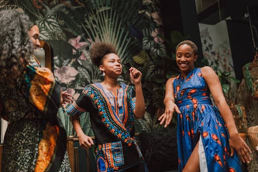 Women performing traditional African dance with colorful attire and joyful expressions.