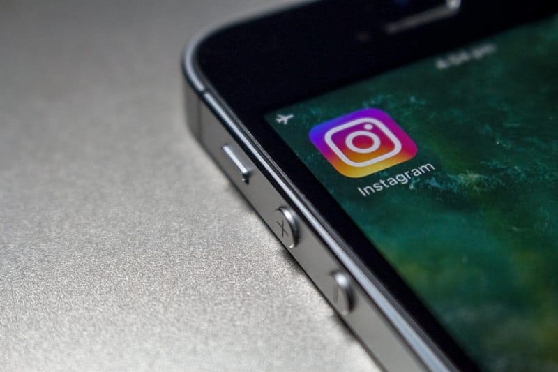 Close-up of a smartphone displaying the Instagram app icon on the screen.
