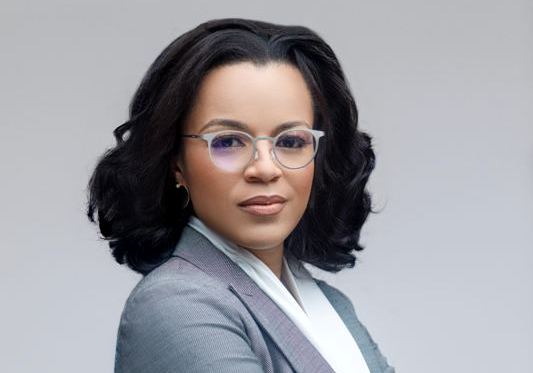 Professional woman in business attire with glasses, representing climate finance initiatives.