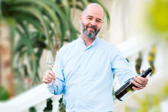 Man enjoying wine outdoors with a glass and bottle, highlighting wine trends 2022.