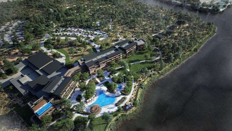 Aerial view of a luxury hotel resort in Africa featuring pools, lush greenery, and scenic lakeside s.