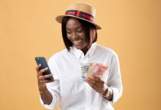 Woman using phone and holding cash, promoting referral bonuses for government workers.