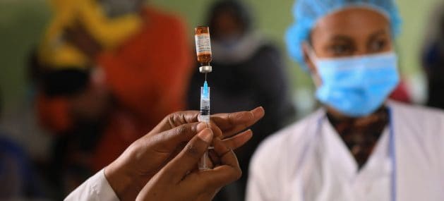 Healthcare worker prepares a Covid-19 vaccine injection in Africa.