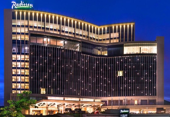 Radisson Hotel building illuminated with lights at night, showcasing modern architecture in Africa.