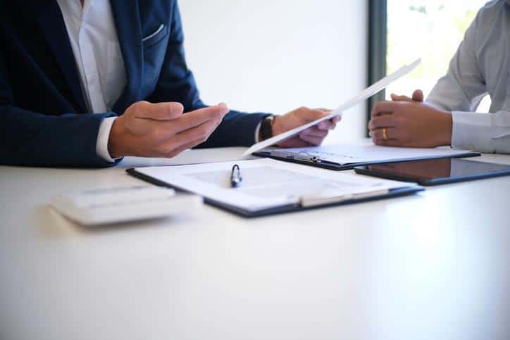 Business professionals reviewing insurance documents during a consultation.