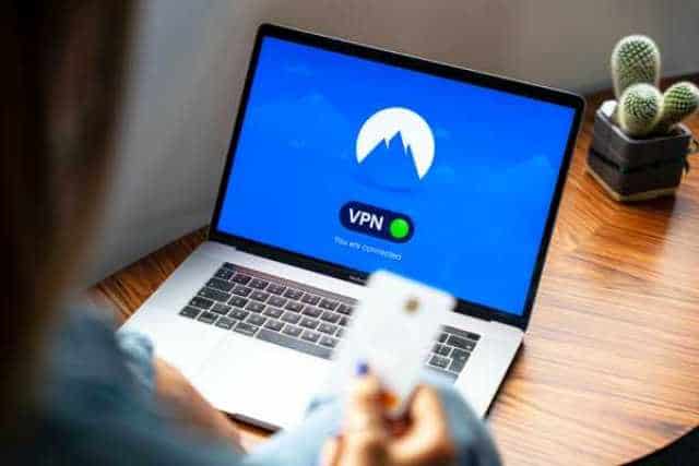 Person using a VPN on a laptop with a VPN icon on screen.