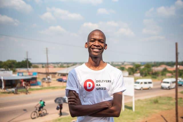 Young South African entrepreneur smiling outdoors in casual attire.