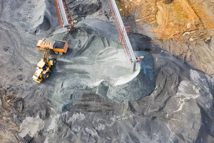 Excavator working on mineral extraction at a Ghanaian mining site with heavy machinery.