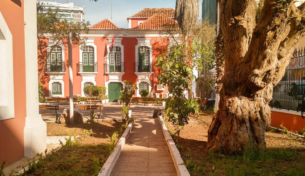 Colonial architecture in Angola with colorful buildings and lush greenery.
