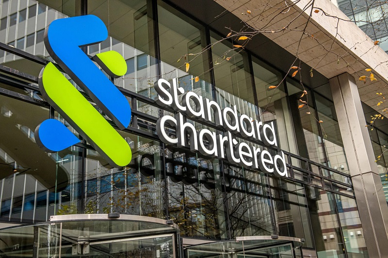 Modern Standard Chartered bank building in Africa with prominent logo.