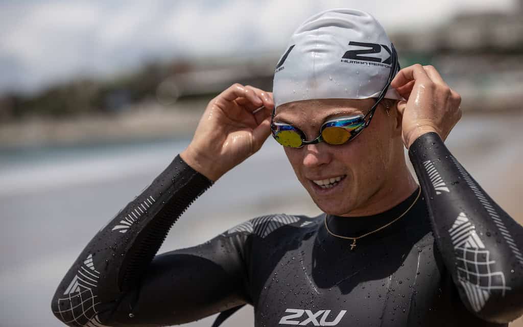 Triathlete Jamie Riddle wearing 2XU sportswear and goggles, ready for competition.