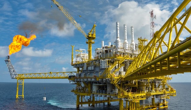 Oil and gas offshore platform with flames and cranes, symbolizing energy development in Africa.
