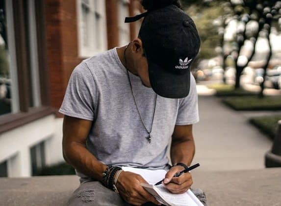 Young African man studying outdoors, exploring economic opportunities for youth.