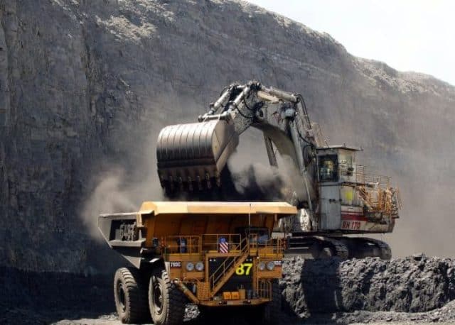 Mining machinery removing coal in an open-pit mine.