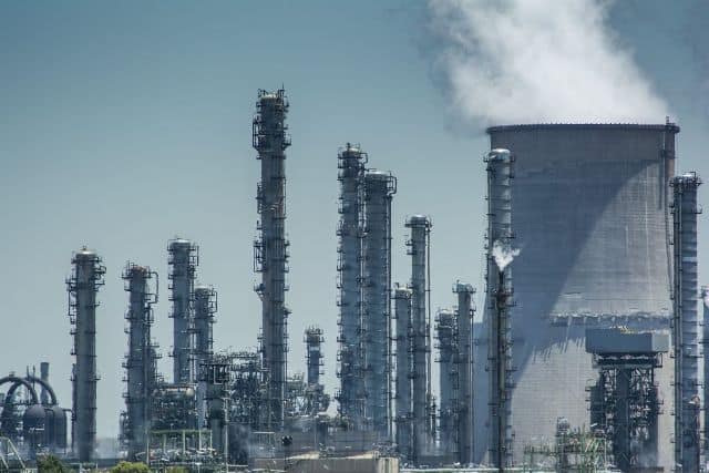 Power plant with smokestacks emitting smoke, emphasizing energy and environmental issues in Africa.