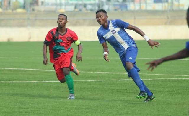 Two African soccer players competing on the field during a match.