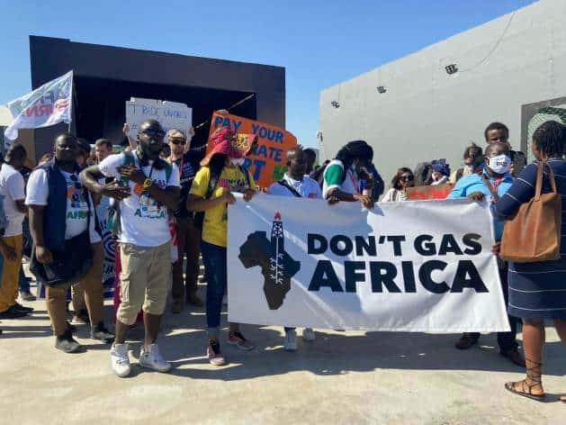 Protesters in Africa holding a "Don't Gas Africa" banner against fossil fuel projects.