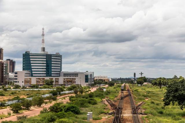 Urban skyline with modern buildings and railway tracks in an African city.