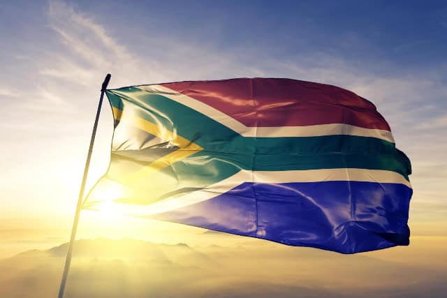 South African flag waving at sunset, symbolizing energy and national pride.