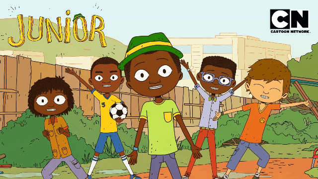 Young African boy with a green hat, smiling, in a lively outdoor setting.