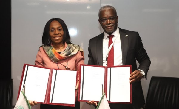 Two professionals holding signed agreements during a partnership event.