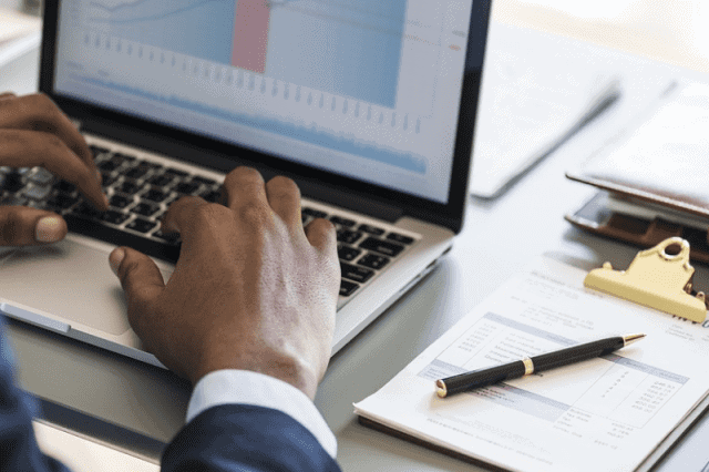 Business professional analyzing growth sectors in Africa on a laptop.