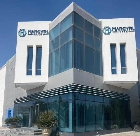 Modern Marcyrl building with glass facade and company logos.