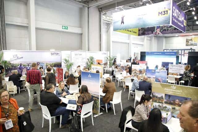 Exhibition of tourism professionals networking and sharing ideas at a trade event.