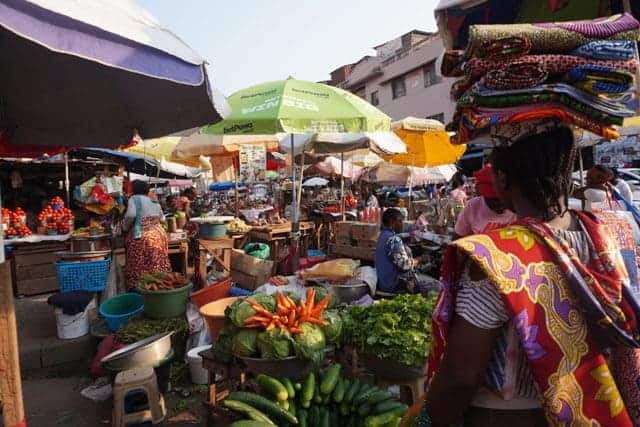 Colorful street vendors' market scene in Kigali, Rwanda, showcasing diverse fresh produce and lively.