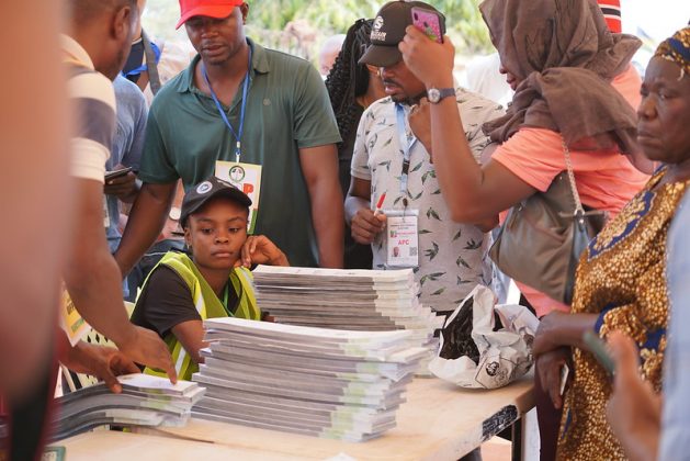 Election voting process in Nigeria with young voters and election officials.
