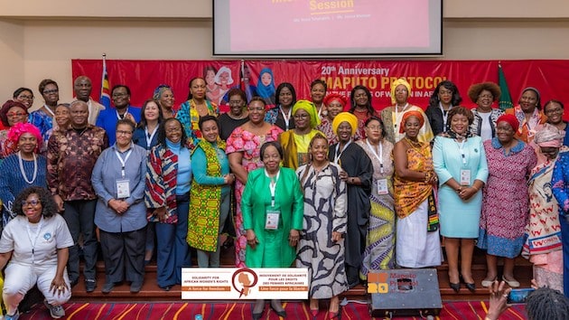 Group of women and men at Africa women’s rights conference, celebrating progress.